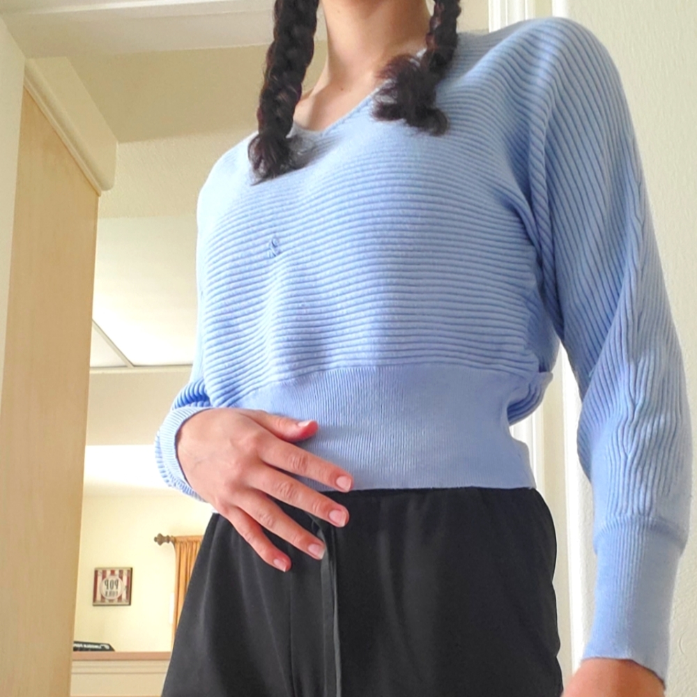 A light purple long sleeve shirt with an opening in the back